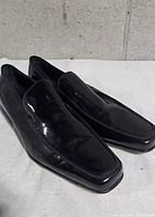 Side view of both loafers showing patent leather finish and profile