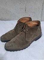 Side view of both boots showing suede uppers, lacing, outsole, overall wear