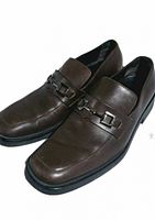 Top angled view showing pair of brown leather loafers and horsebit hardware