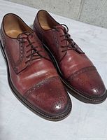 Top view of both shoes showing cap-toe brogue design and lacing