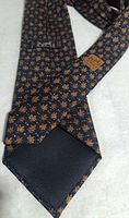 Full length view of tie front and back showing pattern and navy tipping