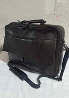 Front view showing leather exterior, flap pocket, shoulder strap, top handle