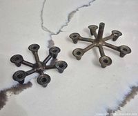 Top view of two Denco cast iron star candle holders showing six taper sockets each