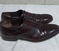 Left side view of both shoes showing leather uppers, cap-toe and brogue detail