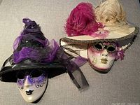 Both Venetian masks side by side on fabric background