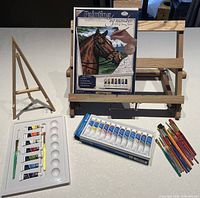 Full lot view: easel, paint-by-number canvas, paint sets, brushes