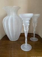 Front view of frosted glass vase and two candle holders