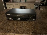 Front view showing tape slot, front control panel, 4-Head Hi-Fi Stereo marking and front RCA inputs