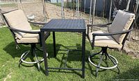 Full view of the bistro set showing table and both chairs with cushions
