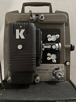 Front view of Keystone Eluxe K-91 projector showing K logo, lens area, control panel, and model plate