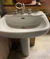 Front view of Tenax pedestal sink showing basin, pedestal, and faucet set