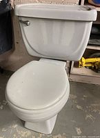 left profile of Tenax toilet showing bowl, tank, lever