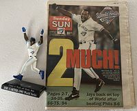 Newspaper front page and figurine side by side