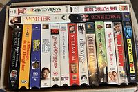 Box of 17 VHS tapes showing front spines