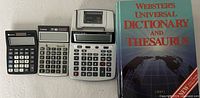 Group shot showing three calculators and dictionary