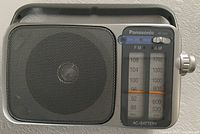 Front view showing speaker grille, tuning scale, carry handle