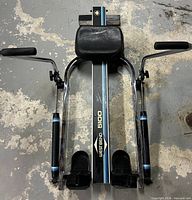 Top view of folded West Bend 5100 rower showing hydraulic arms, seat, footrests, decals