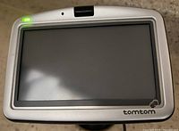 Front view of TomTom GPS unit powered off showing screen and casing