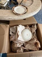 open box with wrapped Alfred Meakin Caledonia pieces, one saucer underside visible