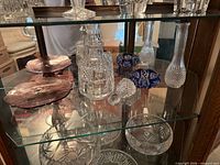 Shelf showing decanter, stopper, blue bowls, bud vase