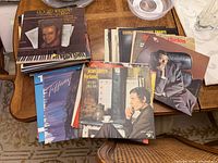 Stacks of vinyl LPs showing Roger Williams album on top of left stack and several other albums on right stack