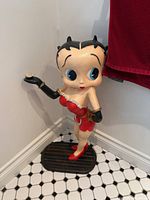 Full view of Betty Boop statue standing in corner on base