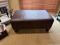 Top and front view of brown leather ottoman