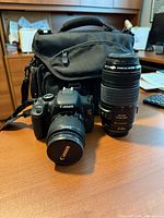 Camera body with 18-55mm lens, 70-300mm lens, carrying case visible