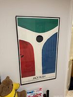 Full view of framed Jack Bush poster on wall showing abstract design, frame and glass