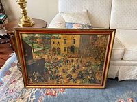 Full view of framed print leaning against sofa, shows frame color and general size