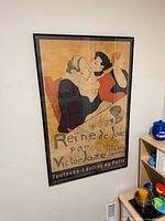 Overall view of framed Toulouse-Lautrec Reine de Joie poster on wall