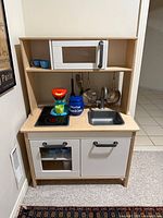 Front view of play kitchen with all accessories displayed