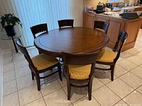 round wood dining table with six chairs around it