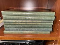 Stack of seven green hardcover Ciba medical illustration volumes showing spine titles for Reproductive, Respiratory, Nervous systems