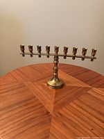 Front view of brass menorah on wood table