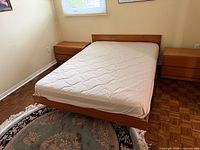 Full view of bed frame with mattress, headboard, rug partially visible