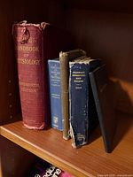 Front view of five vintage medical books standing on shelf