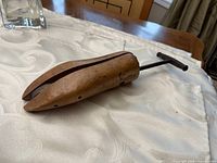 Side view showing full wood form, metal rod, T-handle