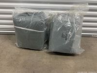 Two sealed gray car covers side by side