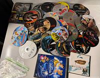 Overview of loose and cased DVD discs spread on table