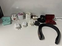 Full lot overview showing earbuds, chargers, neck massager