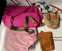 Five items laid out: fuchsia tote, pale pink bag, tan pouch, straw tote, detachable strap visible