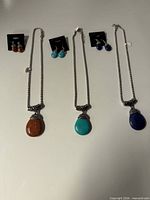 Overall lot showing three necklaces and three earring pairs