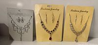 Three necklace and earring sets on display cards