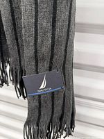Close-up of fringe end showing Nautica tag and stripe pattern