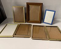 Seven photo frames laid out to show variety in materials and sizes