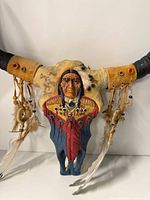 Front view of longhorn skull wall hanger with detailed painting and adornments