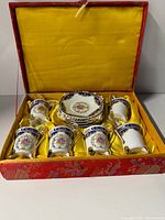 open presentation box showing six demitasse cups and stacked saucers