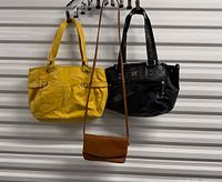 Yellow tote, black shoulder bag, brown crossbody hanging