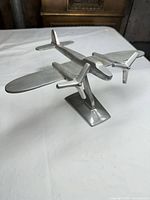 Front perspective of aluminum airplane model on stand